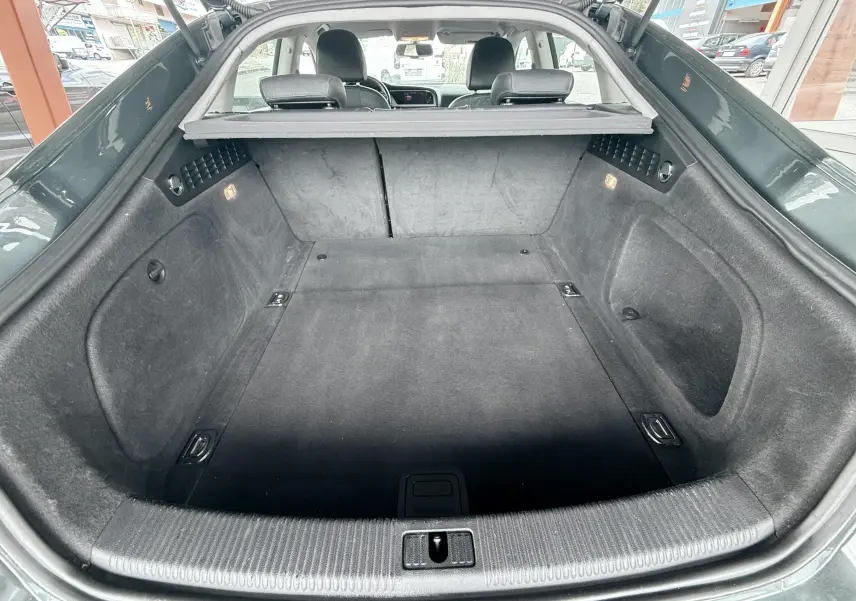 Vue arrière du coffre spacieux et propre de l'Audi A5 Sportback gris dauphin, avec banquette arrière visible.