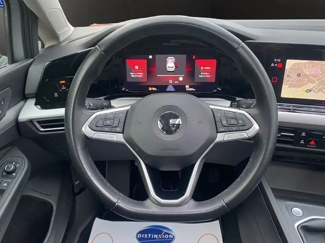 Vue frontale du volant noir de la Volkswagen Golf VIII 2.0 TDI 115 Life avec tableau de bord digital et écran central tactile.