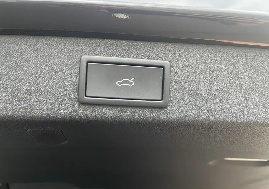 Bouton d'ouverture électrique du hayon sur la garniture intérieure noire du coffre du Skoda Kodiaq 2024.