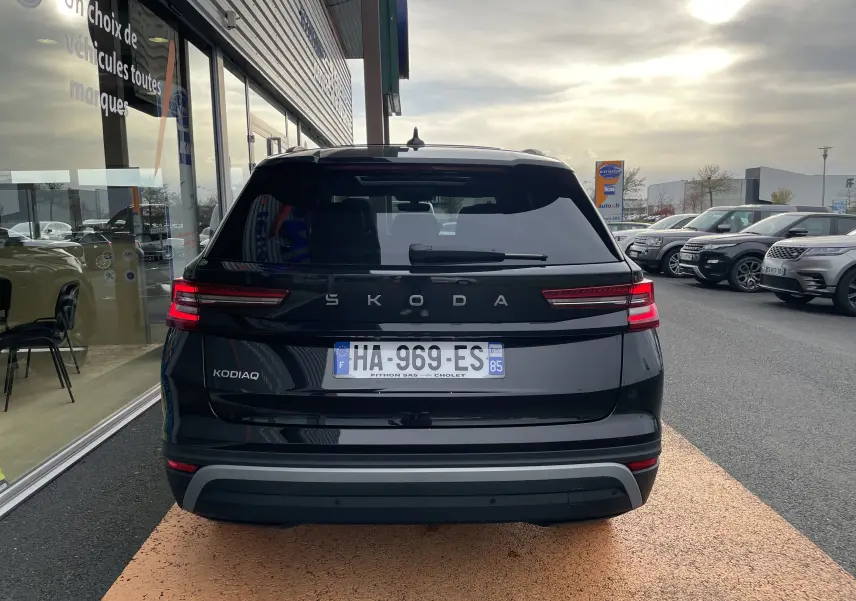 Vue arrière d'un Skoda Kodiaq noir métal 2024, avec feux LED allumés et plaque d'immatriculation française visible.