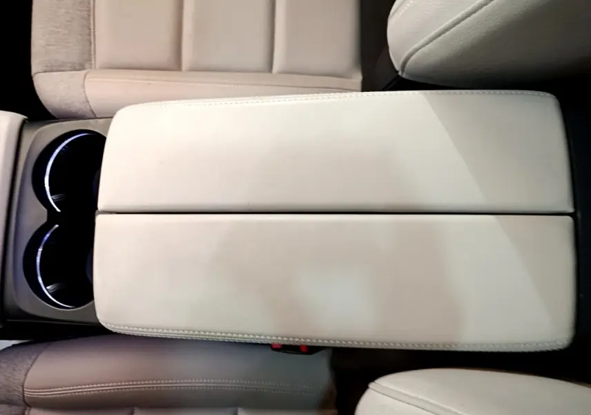 Gros plan sur l'accoudoir central beige et les porte-gobelets éclairés du Citroën C5 Aircross Hybrid 225 ë-EAT8 Shine Pack.