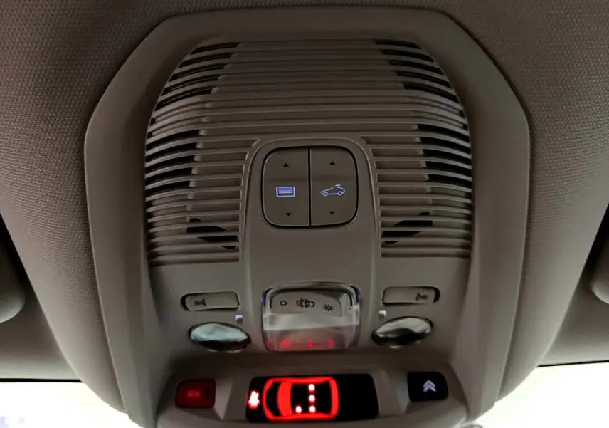 Vue intérieure du plafonnier avec commandes d'ouverture de toit et bouton SOS du Citroën C5 Aircross blanc hybride 2021.