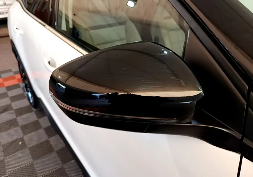 Rétroviseur noir en gros plan côté gauche d’un Citroën C5 Aircross blanc, vue partielle latérale.