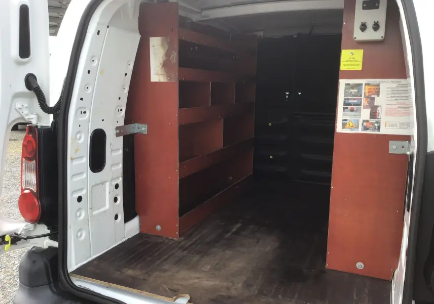 Vue arrière du Citroën Berlingo blanc 2018 avec portes ouvertes montrant l'aménagement intérieur en bois pour rangement.