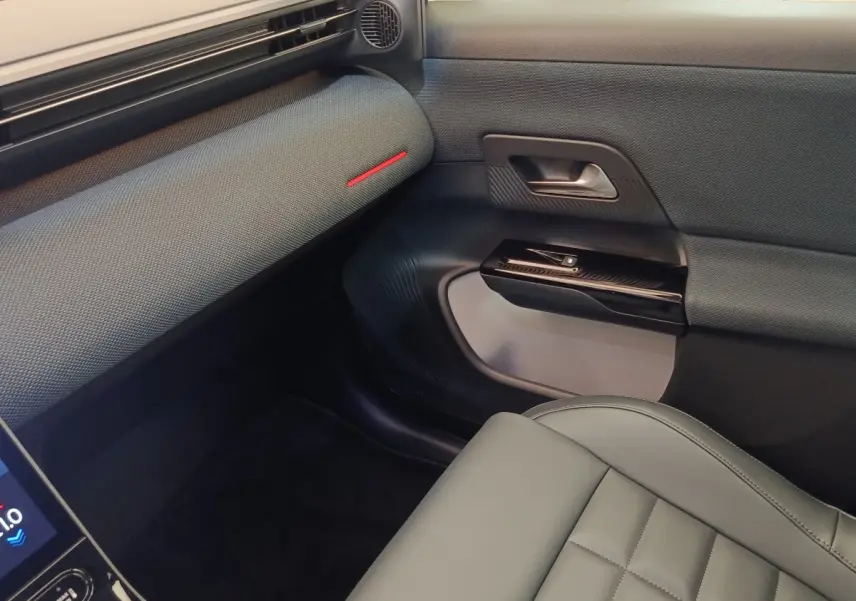 Vue intérieure côté passager avant du Citroën C5 Hybride 2026, avec sellerie grise et garnitures noires texturées.