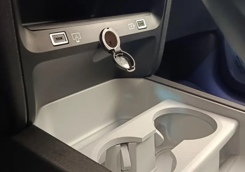 Gros plan sur la console centrale intérieure grise de la Citroën C5 Hybride avec prises USB et prise 12V ouverte.