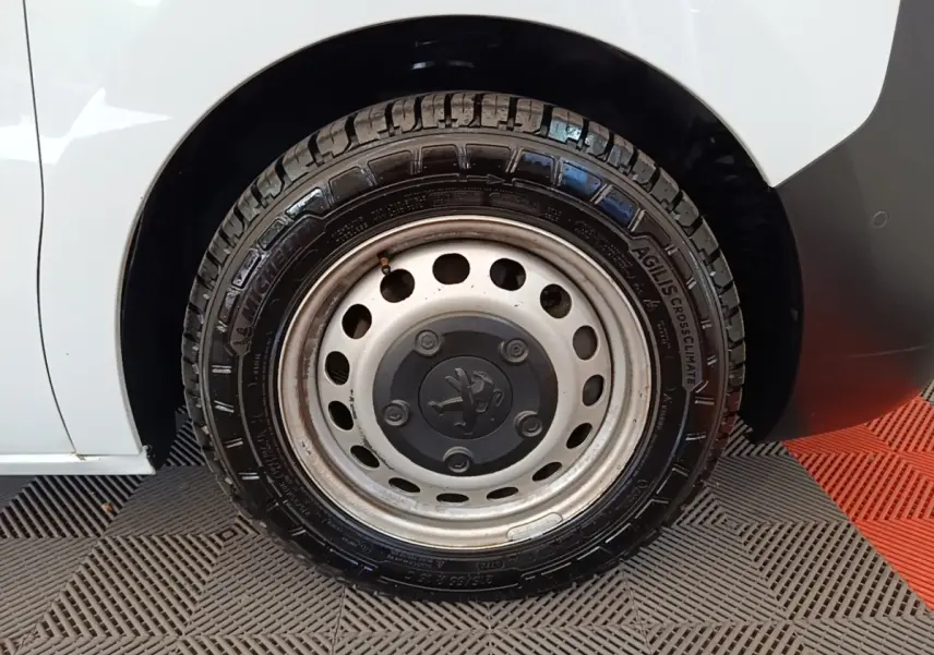 Gros plan sur la roue arrière droite blanche du Peugeot Expert Fourgon avec jante acier et logo Peugeot central.