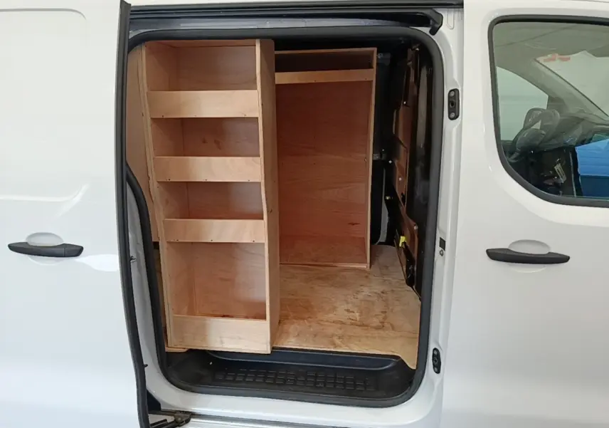 Vue latérale droite d’un Peugeot Expert Fourgon blanc 2023 avec porte coulissante ouverte et aménagements bois dans la zone de chargement.