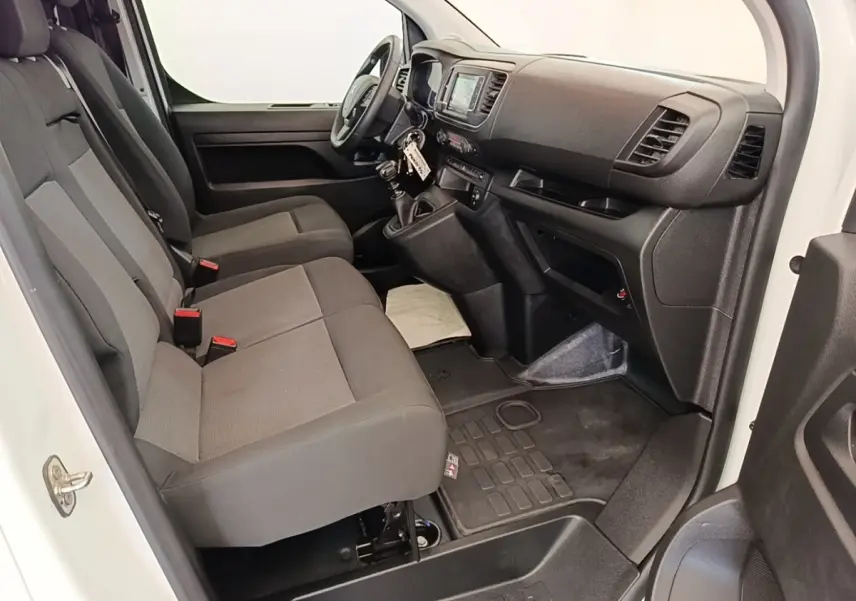 Vue intérieure côté conducteur du Peugeot Expert Fourgon blanc, montrant les sièges avant et le tableau de bord avec écran tactile.