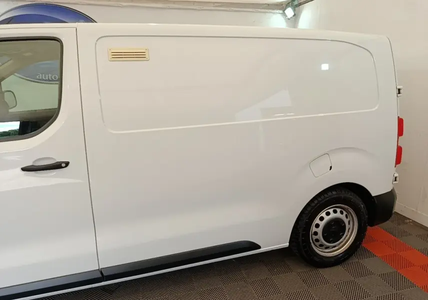 Vue latérale droite d’un Peugeot Expert Fourgon blanc, avec porte latérale pleine et jante acier simple.