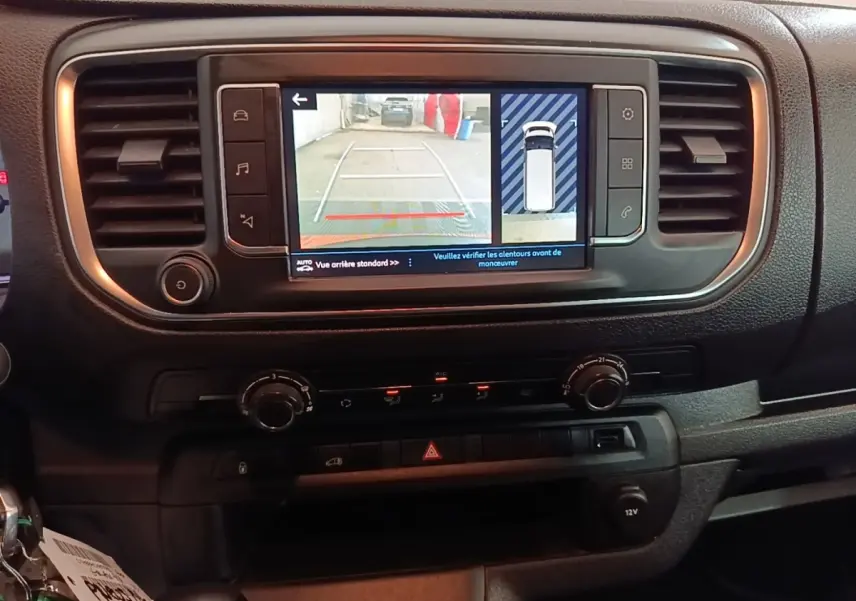 Vue rapprochée de l’écran tactile central du Peugeot Expert Fourgon blanc 2023 montrant l’aide au stationnement arrière.