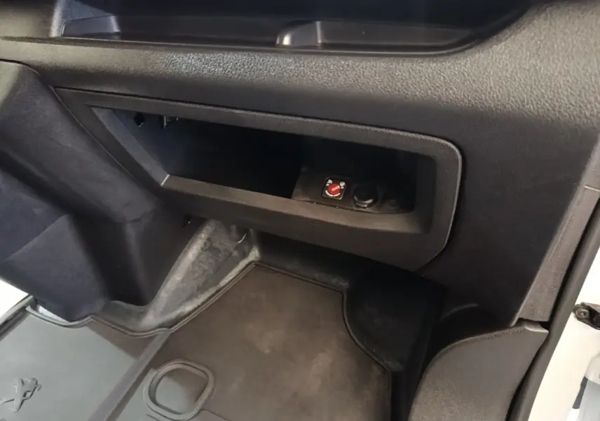 Vue intérieure côté passager du Peugeot Expert Fourgon blanc, avec rangement ouvert et moquette noire au sol.