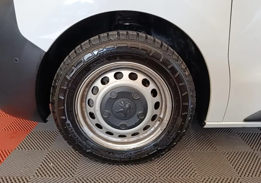 Gros plan sur la roue avant droite du Peugeot Expert Fourgon blanc, avec jante acier et logo Peugeot central.