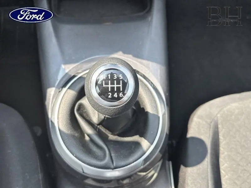 Gros plan sur le levier de vitesses manuel noir du Nissan Juke 2023, avec marquage des six rapports visible.