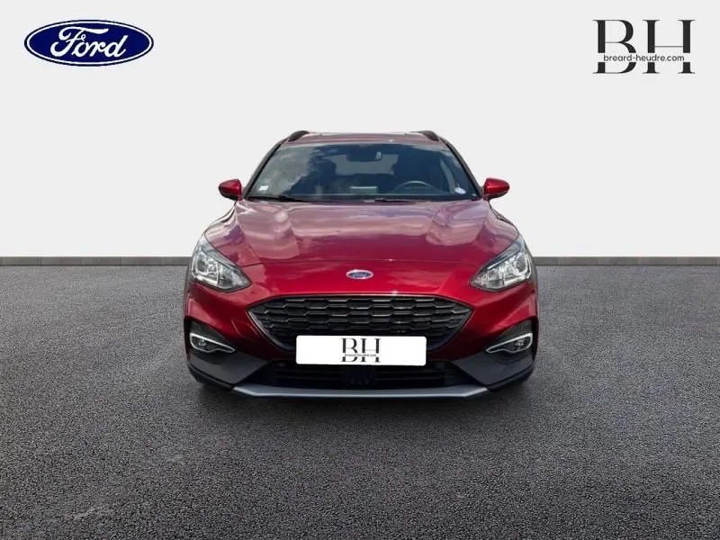 Vue frontale d'une Ford Focus 1.0 EcoBoost 125ch en rouge Premium Candy avec calandre noire et phares LED.