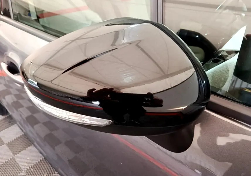Rétroviseur droit noir brillant du Citroën C3 Aircross gris foncé, avec clignotant intégré, vue rapprochée.