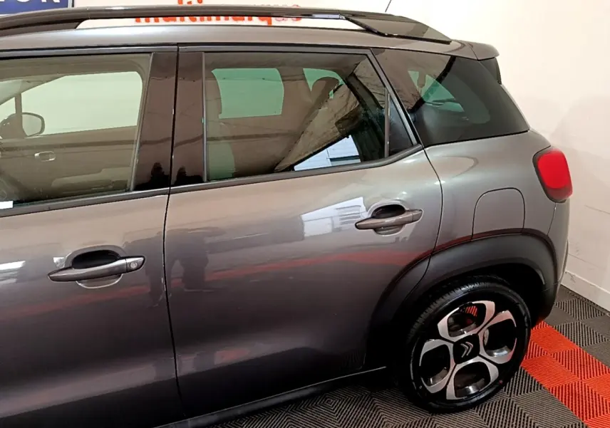 Vue latérale droite d'un Citroën C3 Aircross gris foncé avec jantes alliage et toit noir contrasté.