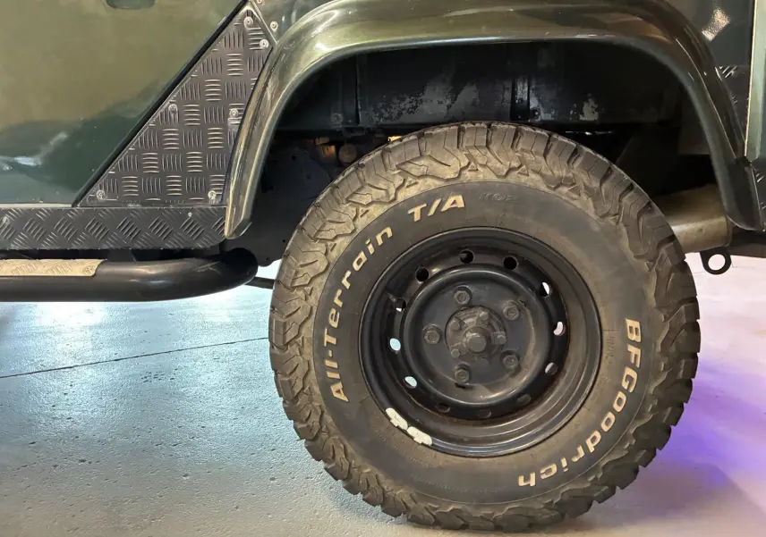 Gros plan sur la roue arrière droite d’un Land Rover Defender 110 vert avec pneu BFGoodrich tout-terrain.