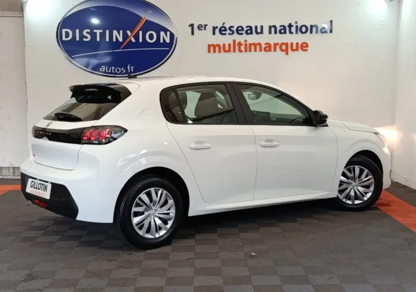 Peugeot 208 blanche vue de profil droit en intérieur, avec feux arrière LED et jantes alliage.