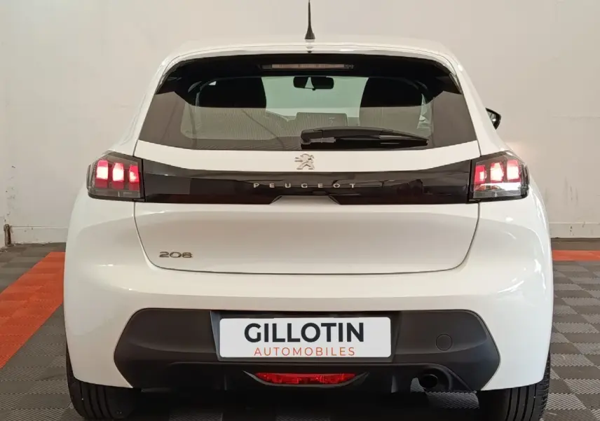 Vue arrière d'une Peugeot 208 blanche 2022 avec feux LED et logo Peugeot sur bande noire brillante.