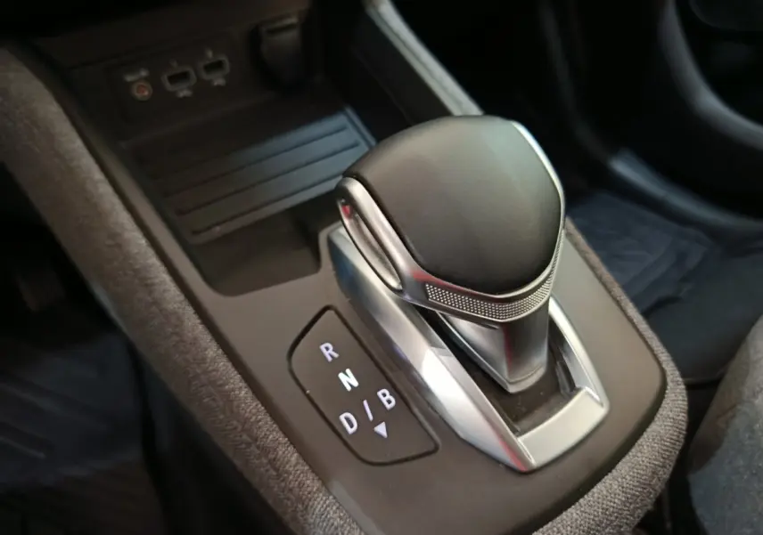Gros plan sur la commande de boîte automatique noire et argentée de la Renault ZOE blanche, version électrique 2023.