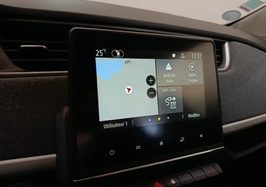Écran tactile central du tableau de bord de la Renault ZOE blanche, affichant navigation et options connectées.