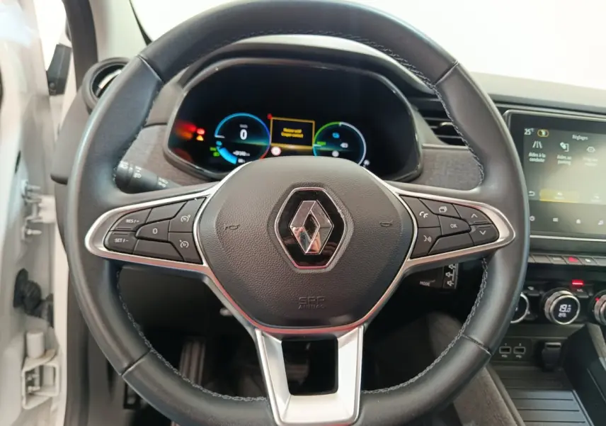 Vue rapprochée du volant en cuir synthétique noir de la Renault ZOE blanche 2023 avec tableau de bord digital.