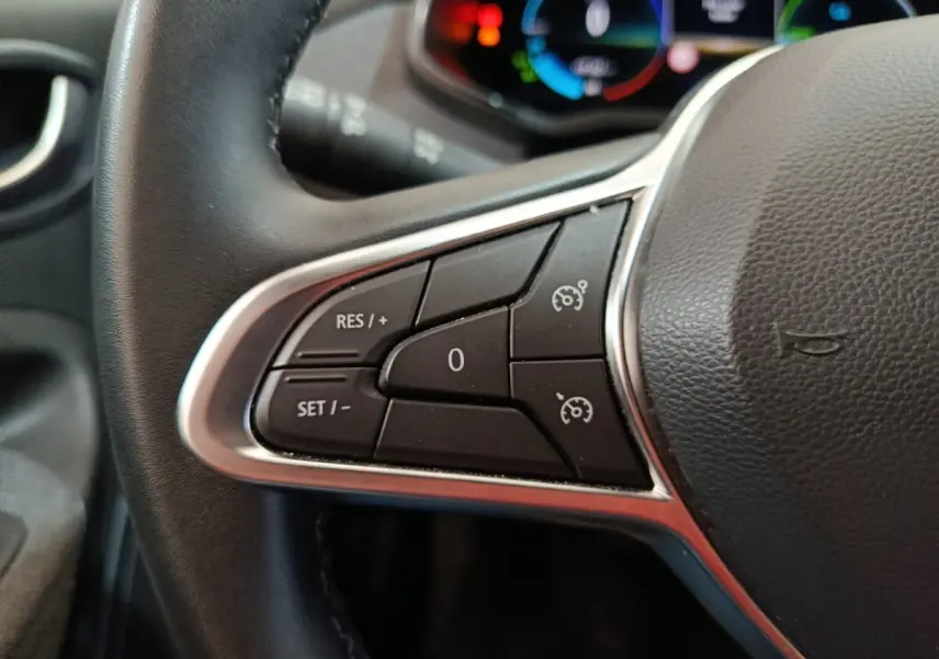 Gros plan sur le volant cuir synthétique de la Renault ZOE blanc, avec commandes multifonctions visibles.