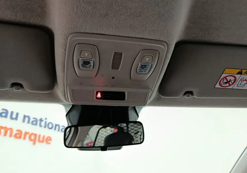 Vue intérieure du plafonnier et du rétroviseur central de la Renault ZOE blanche, version 2023.