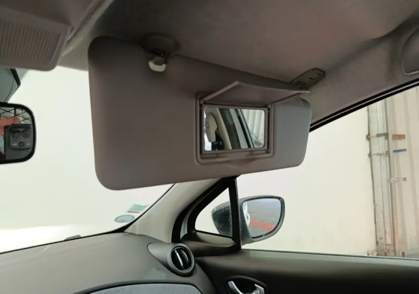 Intérieur de Renault ZOE blanc 2023, vue côté conducteur sur pare-soleil avec miroir de courtoisie ouvert.