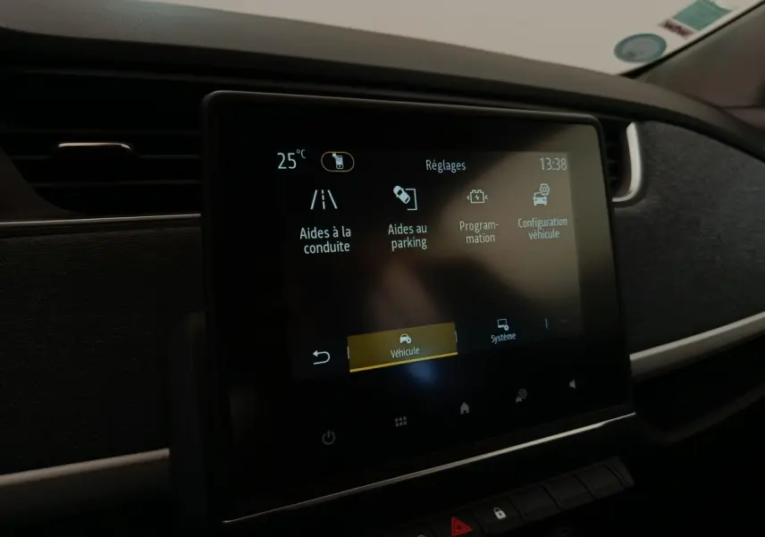 Écran tactile central affichant les réglages d’aides à la conduite dans l’habitacle d’une Renault ZOE blanche.