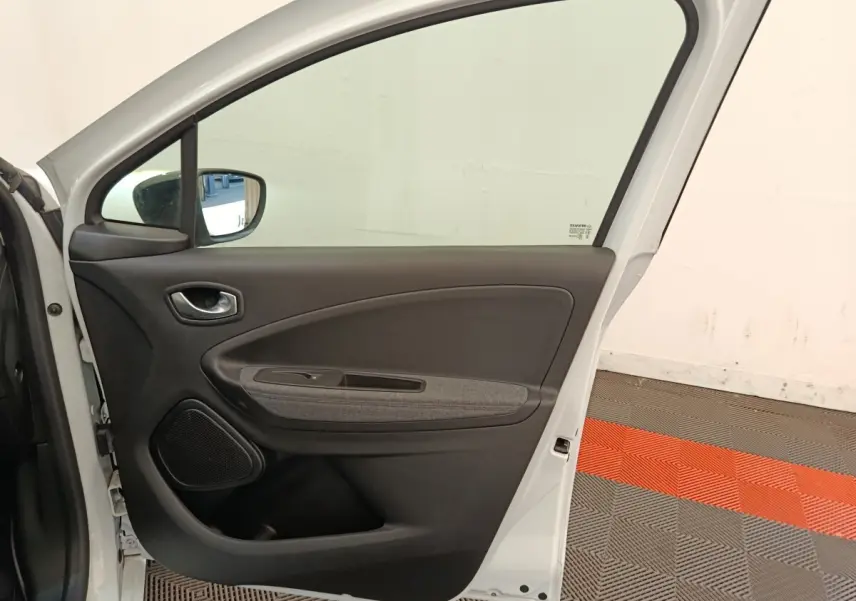 Vue intérieure de la porte arrière droite blanche d'une Renault ZOE 2023 avec garniture noire et grise.