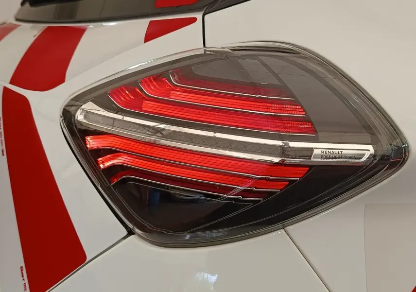 Gros plan sur le feu arrière droit rouge et blanc d'une Renault ZOE blanche avec bandes rouges.