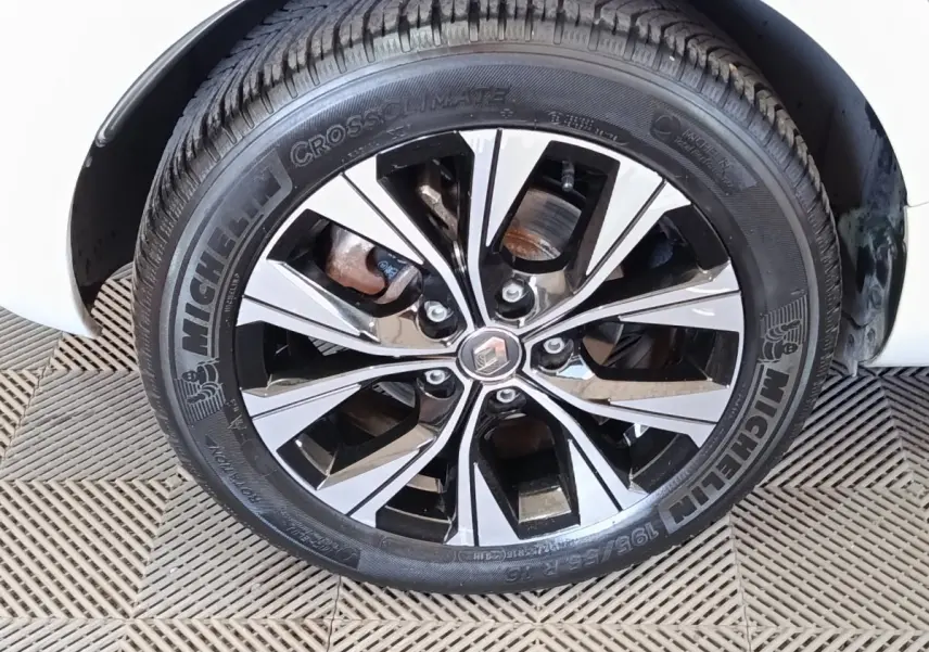 Gros plan sur la roue avant droite de la Renault ZOE blanche, jante alliage bicolore et pneu Michelin visible.