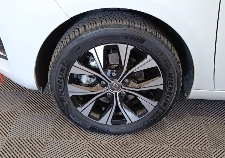 Gros plan sur la roue avant gauche d’une Renault ZOE blanche avec jante alliage bicolore et pneu Michelin.