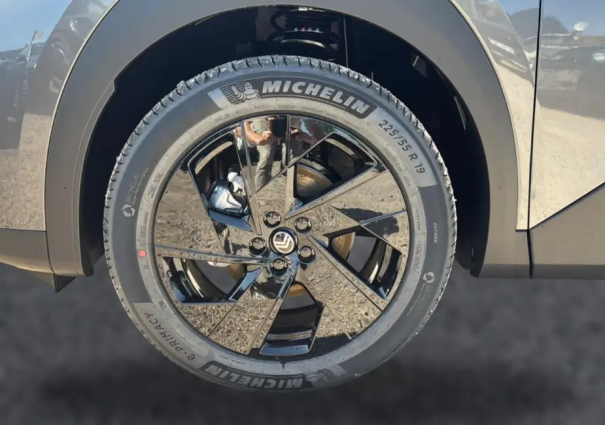 Gros plan sur la roue avant droite du Citroën C5 Aircross gris platinium avec jante alliage noire brillante.