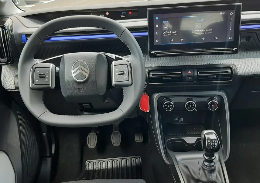 Vue intérieure centrée sur le volant et la console d'une Citroën C3 Turbo 100ch Plus 2026 avec boîte manuelle et écran tactile.