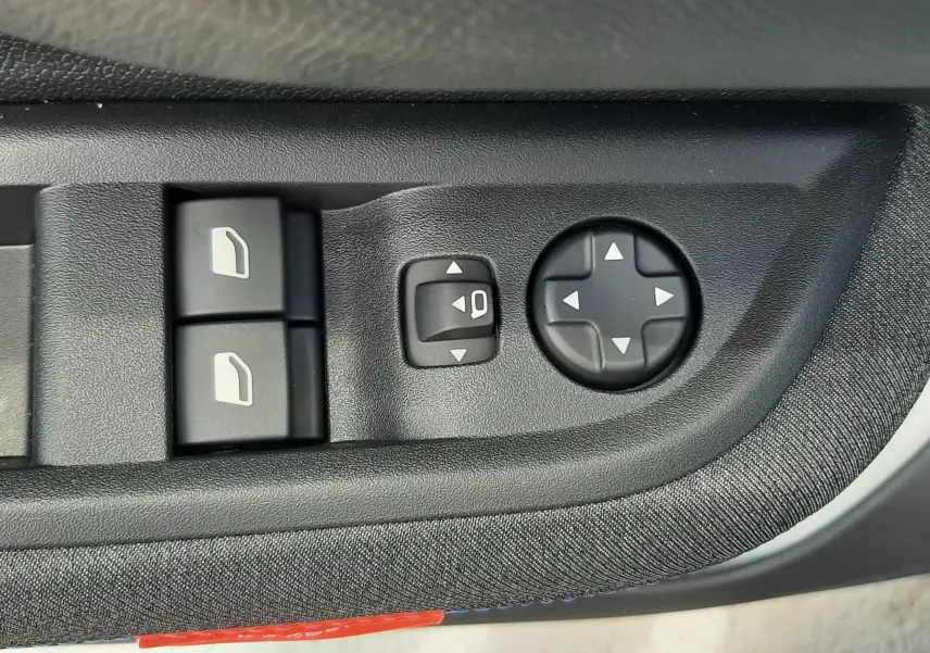 Gros plan sur les commandes de réglage des rétroviseurs et des vitres côté conducteur d'une Citroën C3 Turbo 100ch Plus 2026.