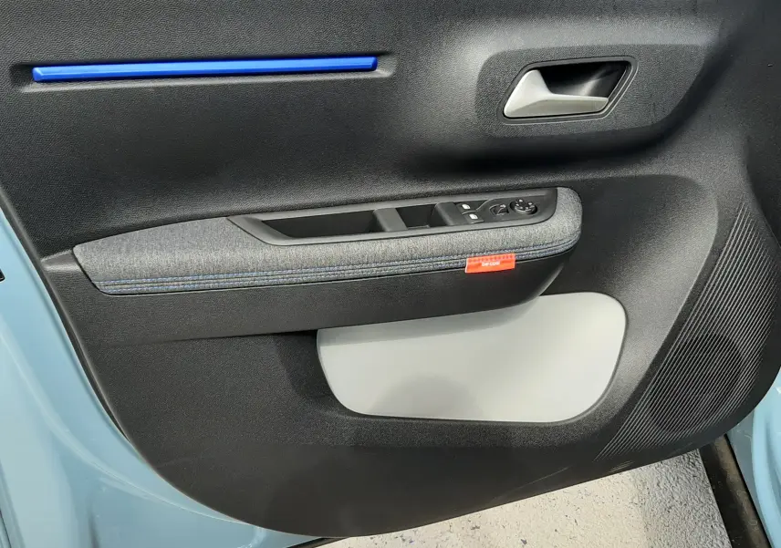 Vue rapprochée de la porte avant gauche de la Citroën C3 bleu Monte Carlo, avec insert bleu et tissu gris.
