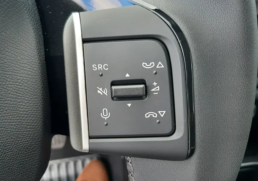 Gros plan sur les commandes multifonctions à gauche du volant de la Citroën C3 Turbo 100ch Plus, intérieur noir.