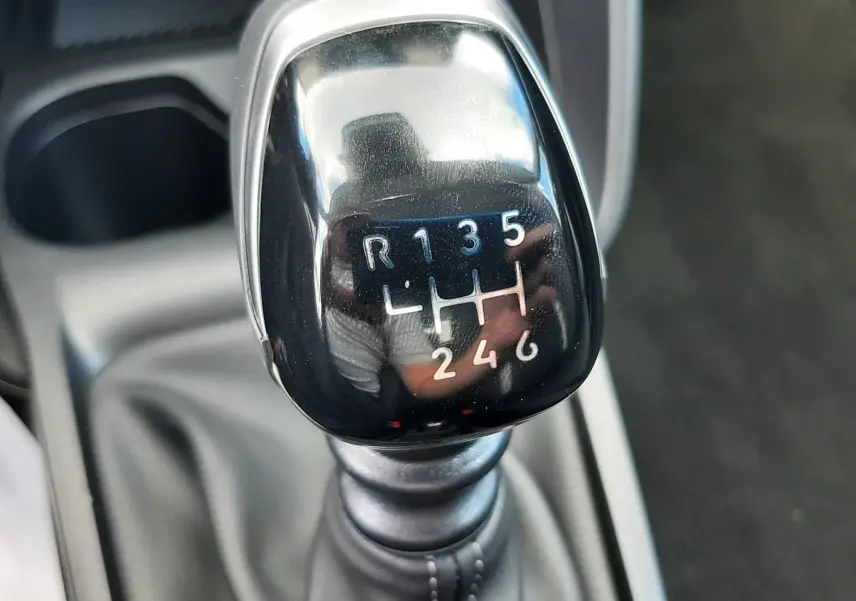 Gros plan sur le levier de vitesses manuel noir de la Citroën C3 Turbo 100ch Plus, avec marquage des six rapports et marche arrière.