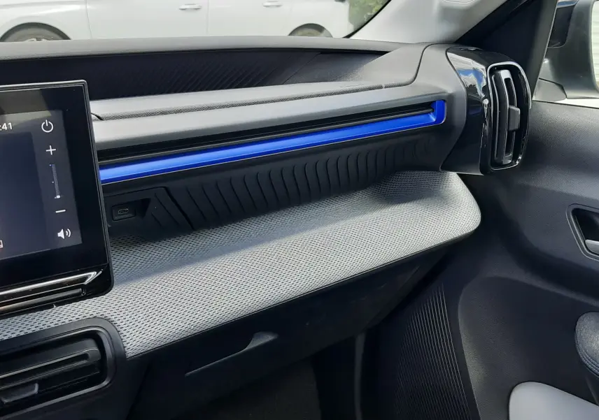 Vue intérieure côté passager du tableau de bord de la Citroën C3 Turbo 100ch Plus 2026 avec bandeau décoratif bleu Monte Carlo.