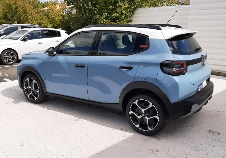 Vue 3/4 arrière droite d'une Citroën C3 bleu Monte Carlo avec toit blanc et jantes noires au design moderne.