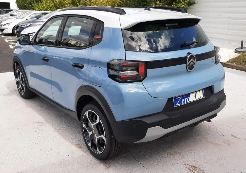 Vue 3/4 arrière droite d'une Citroën C3 Turbo 100ch Plus bleu Monte Carlo avec toit blanc et feux arrière LED noirs.
