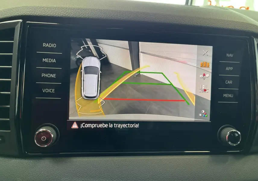 Écran tactile intérieur du Skoda Karoq blanc montrant l'affichage de la caméra de recul avec trajectoire assistée