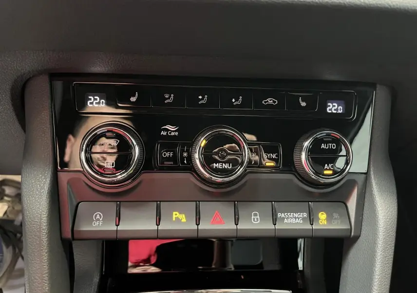 Panneau de commande de la climatisation automatique bi-zone du Skoda Karoq 2025 avec réglages digitaux et boutons noirs brillants.