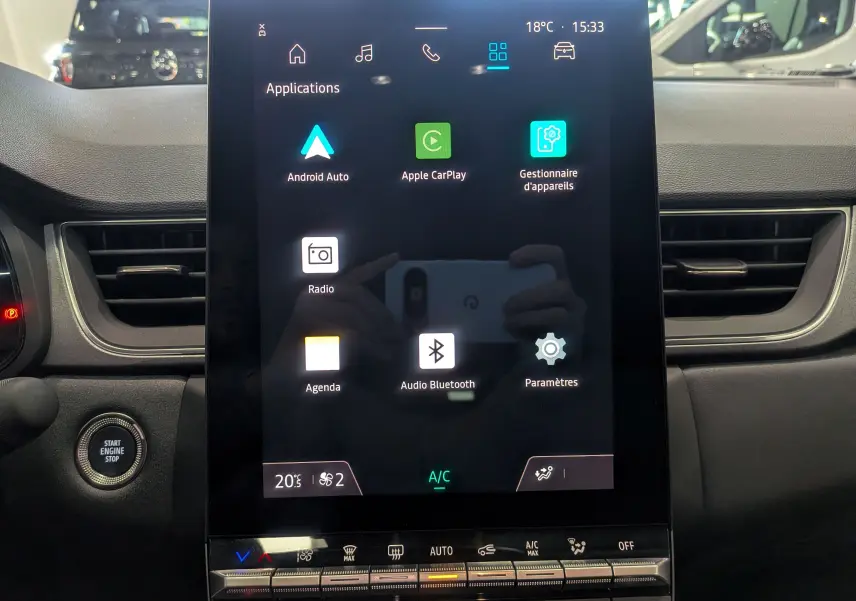 Écran tactile central du tableau de bord du Renault Captur 2025 avec interface multimédia et commandes climatisation visibles.