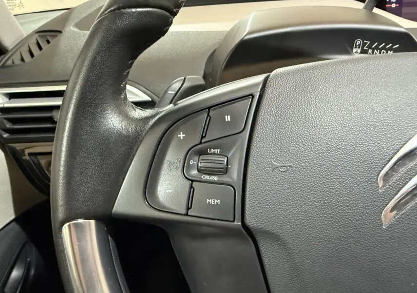 Gros plan sur le volant cuir noir du Citroën C4 Spacetourer 2020 avec commandes de régulateur de vitesse.