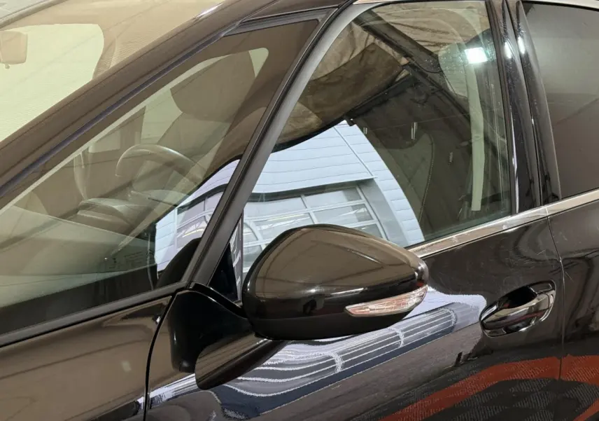 Vue rapprochée du rétroviseur et de la porte côté conducteur d'une Citroën C4 Spacetourer noire brillante.