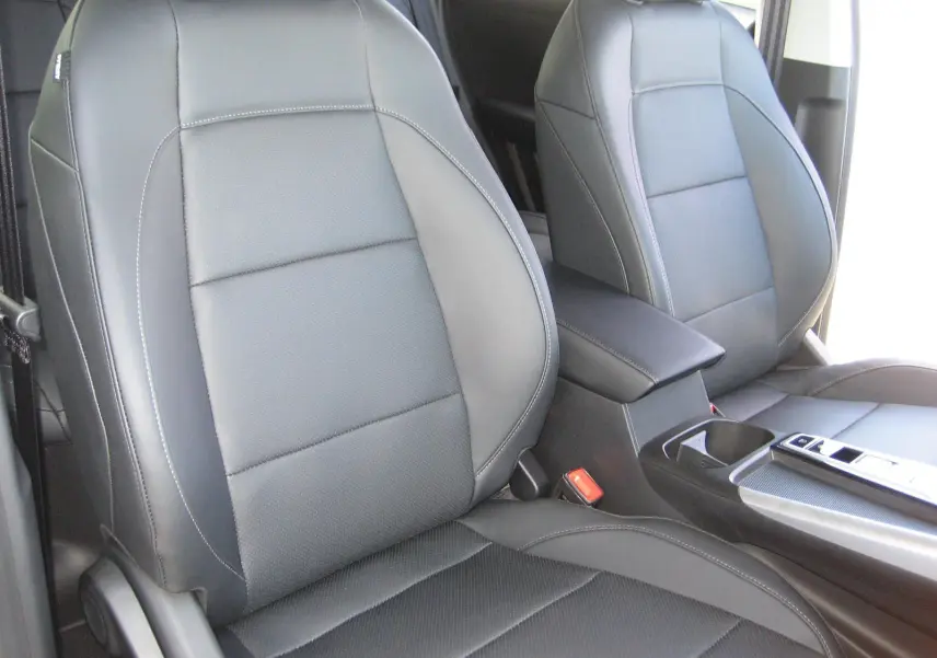 Gros plan sur les sièges avant en cuir noir du MG ZS 1.5 HYBRID+197 LUXURY, avec console centrale visible.